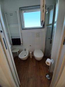 a bathroom with a toilet and a sink and a window at Eolia free parking in Bari