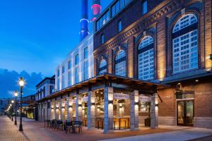 a building with tables and chairs in front of it at JW Marriott Savannah Plant Riverside District in Savannah