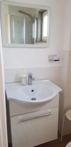 a bathroom with a white sink and a mirror at Eolia free parking in Bari