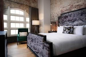 a bedroom with a large bed and a brick wall at JW Marriott Savannah Plant Riverside District in Savannah