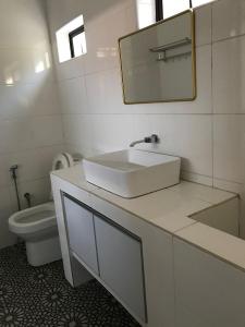 bagno bianco con lavandino e servizi igienici di Yi Tong Nian Home Stay a Sitiawan