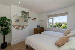 a bedroom with two beds and a mirror at 4 Bedroom House in Newquay