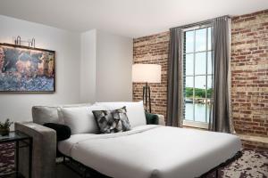 a bedroom with a bed and a brick wall at JW Marriott Savannah Plant Riverside District in Savannah