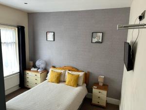 1 dormitorio con 1 cama con almohadas amarillas en The Grosvenor Free house en Scunthorpe
