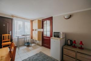 Una cocina con nevera y una mesa con microondas. en Willa Tina, en Karwia