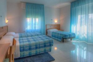 una camera con due letti e tende blu di Hotel Mizar a Chianciano Terme
