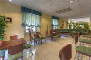 una sala d'attesa con tavoli e sedie in ospedale di Hotel Mizar a Chianciano Terme
