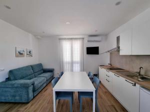 sala de estar con sofá, mesa y cocina en La casa di Enzo, en Tre Fontane
