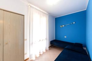 a blue room with a couch and a window at Villaggio Mietta in Castiglioncello