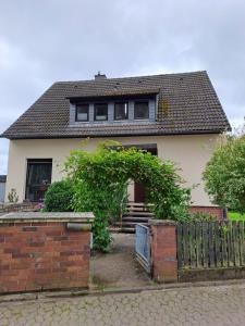 una casa blanca con una puerta y una valla en An den Eichen en Neustadt am Rübenberge