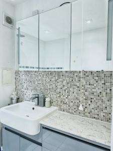 a white bathroom with a sink and a mirror at Twickenham studio private apartment in Twickenham