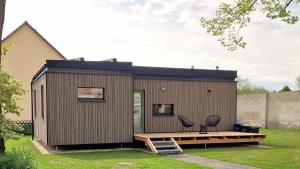 une petite maison avec une terrasse et deux chaises dans l'établissement Tiny Design-Modulhaus mit 33 m², à Grimma