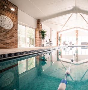 an indoor swimming pool with a brick wall at The Gig House - relaxing countryside spa break in Pentney