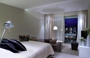 a bedroom with a bed and a living room at Pelagos Suites Hotel & Spa in Kos