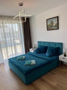 uma cama azul num quarto com uma janela grande em Royal Class Apart Complex Uno Residence em Brasov
