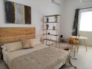 a bedroom with a bed and a table and a desk at Dimore Gilas - Suite Golden in Monopoli
