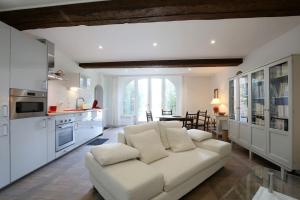 a living room with a white couch and a kitchen at Château de Fontanas, les Lauriers in Grisolles