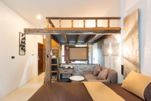 a room with a loft bed and a living room at Tepbunthom Hostel in Bangkok