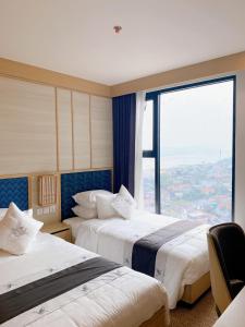 Cette chambre comprend deux lits et une grande fenêtre. dans l'établissement Room in Wyndham Thanh Thuy Hot Spring MyHome, à La Phu