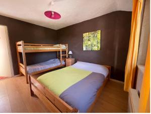 sypialnia z 2 łóżkami piętrowymi i czerwonym światłem w obiekcie La Godille w Andon