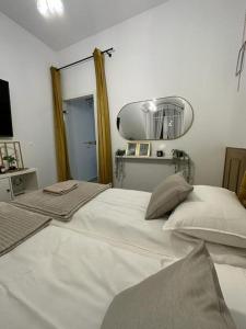 a bedroom with a large white bed and a mirror at Salt INN Apartments No 1 in Wieliczka
