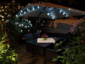 a patio table with an umbrella and lights at Apartments Am Spitalthor in Straubing