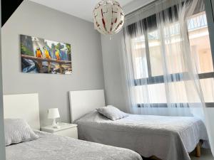 sypialnia z 2 łóżkami i oknem w obiekcie Apartment Playa Elisa Bay w mieście Pilar de la Horadada