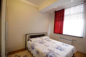 a bedroom with a bed and a red window at Уютная квартира студия in Dushanbe