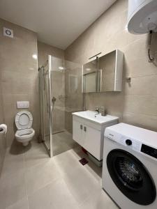a bathroom with a washing machine and a toilet at Apartman Čapljina in Čapljina