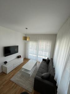 a living room with a couch and a tv at Apartman Čapljina in Čapljina