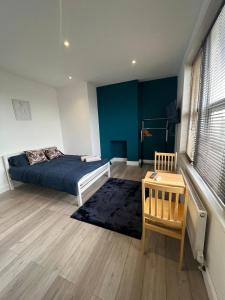 Un dormitorio con una cama y una mesa. en Barnet Studios en New Southgate