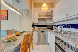 a kitchen with a sink and a counter with chairs at Apartment in Yucca park in Adeje