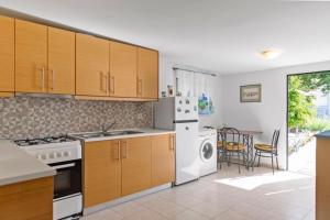 a kitchen with a white refrigerator and a table with chairs at Platanos Villa in Haraki