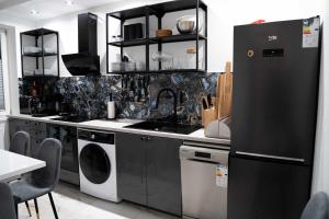 a kitchen with a black refrigerator and a dishwasher at Apartamenty całoroczne "Eleganza" jacuzzi-sauny in Nadole