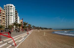 a beach with buildings and the ocean and a sandy beach at Spacious vintage 18 in Vinarós