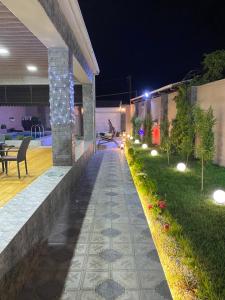 a backyard with a stone walkway at night at Elite Novkhany-Corat Villa in Corat