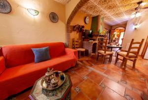 a living room with an orange couch and a table at Apartamentos La Granja in Hinojares