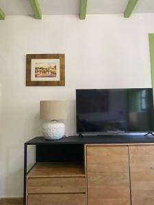 a television on a cabinet with a lamp on it at La Lozana in Jete