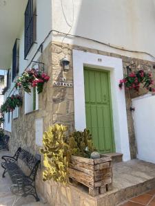 a building with a green door and a bench at La Lozana in Jete