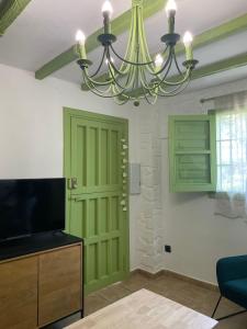 a living room with a green door and a chandelier at La Lozana in Jete