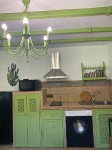 a kitchen with green cabinets and a washing machine at La Lozana in Jete