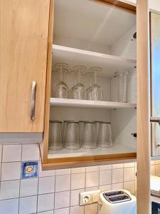 einen Küchenschrank mit Glasscheiben darin in der Unterkunft Negrelli Appartement in Feldkirch