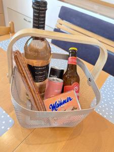 a basket with two bottles of alcohol on a table at Negrelli Appartement in Feldkirch