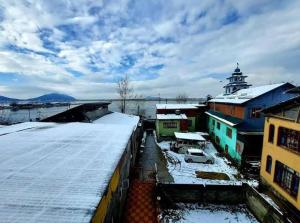 a group of buildings with snow on the roofs at Nishat lake view resort in Srinagar