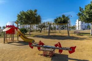a park with a playground with a slide at Appartement op een toplocatie. in Las Pedreñas