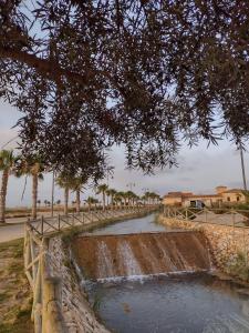 a small waterfall in a stone wall with palm trees at Appartement op een toplocatie. in Las Pedreñas