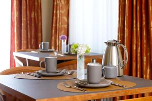 a table with plates and utensils on top at Hotel Regina -Garni Köln in Cologne