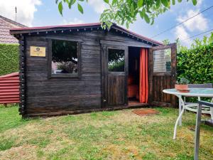a wooden shed with a door and a table at La Cabane de l’Explorateur in Cholet