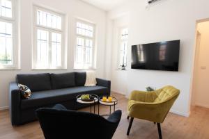 a living room with a couch and a chair at PORT CITY HAIFA - Authentic German Colony Apartments in Haifa