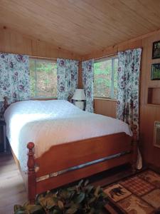 a bedroom with a bed in a room with windows at Camp Lake Bear in South Colton